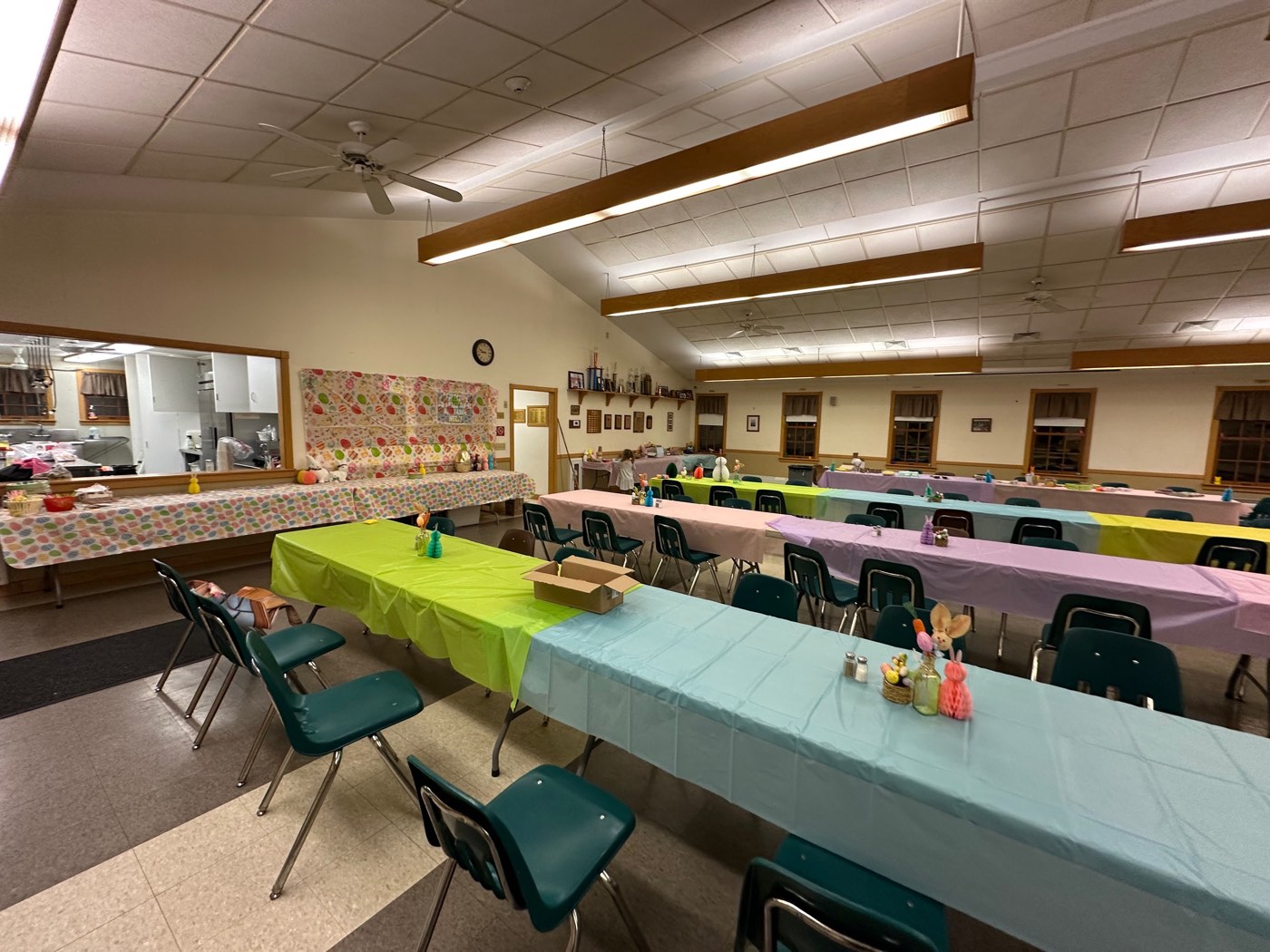 The hall set with tables and chairs and pastel linens for a spring luncheon.